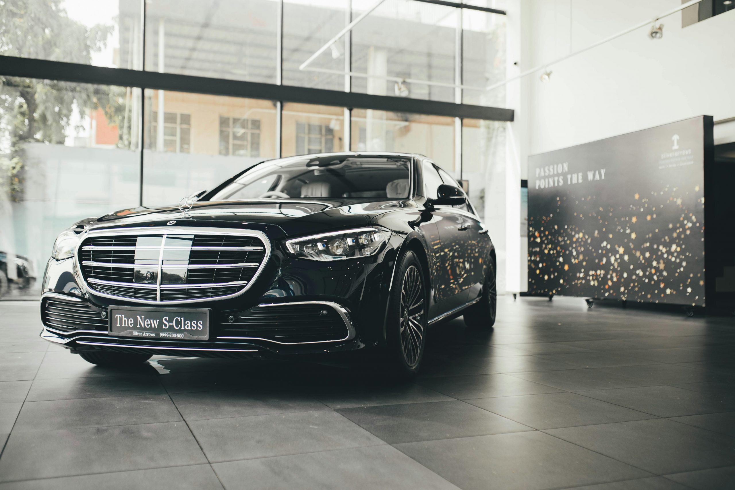 Elegant Mercedes-Benz S-Class showcased in a classy New Delhi showroom, highlighting modern luxury.